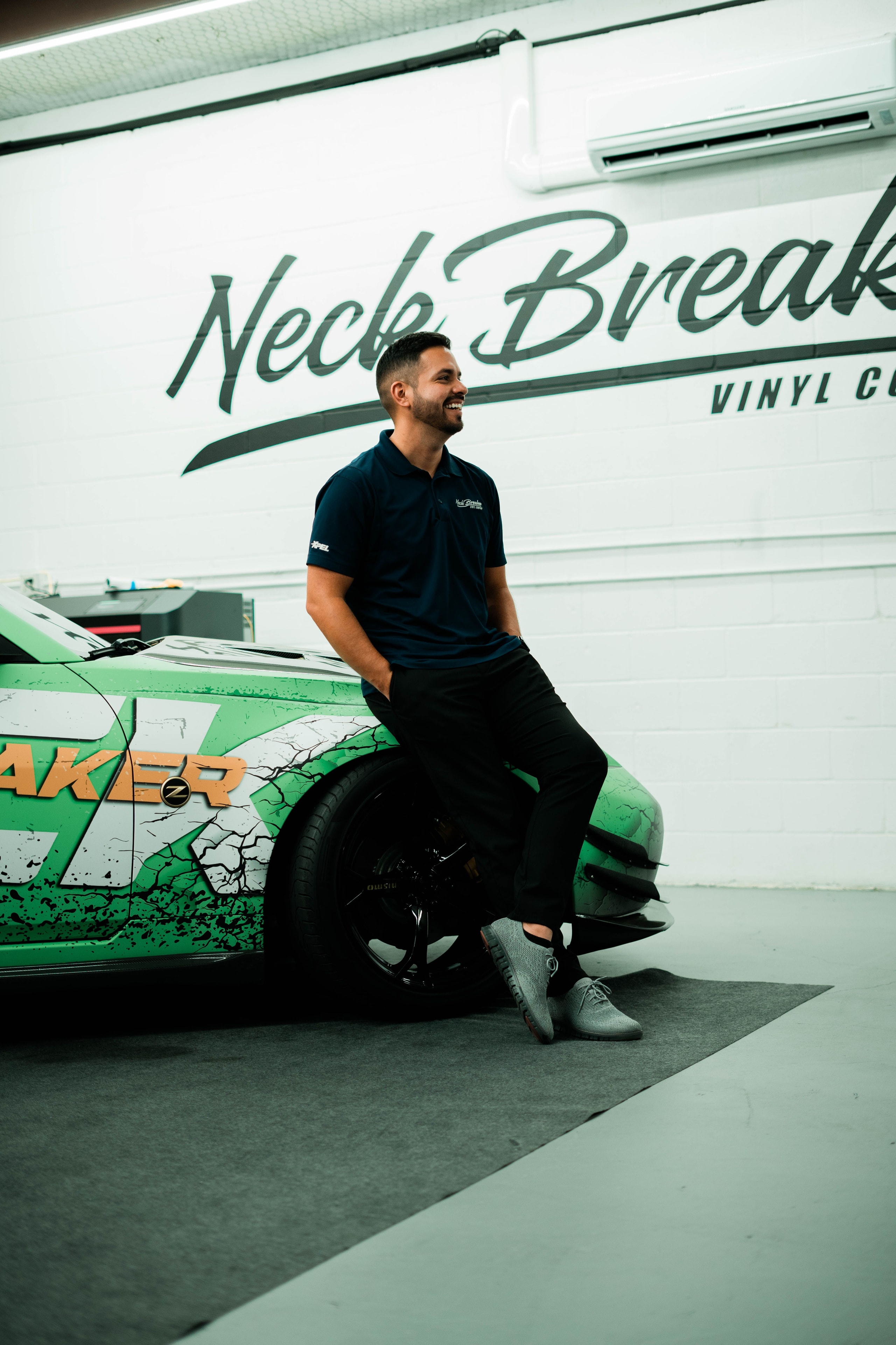 Patric — Neck Breaker Vinyl Co founder leaning on green Z wrap